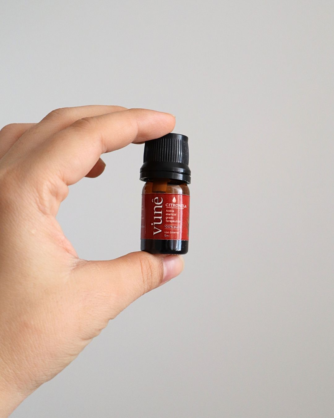 Frasco de aceite esencial de citronela Vuné de 5ml sostenido en la mano