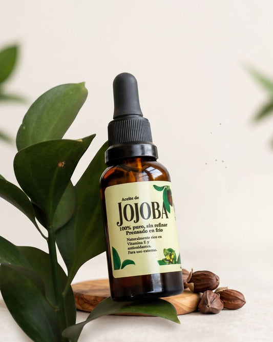 Frasco de aceite de jojoba orgánico con semillas y hoja verde