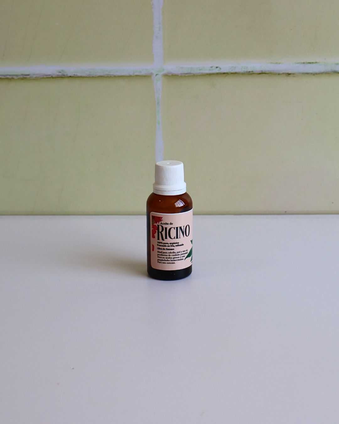 Aceite de ricino puro en frasco pequeño con flores naturales