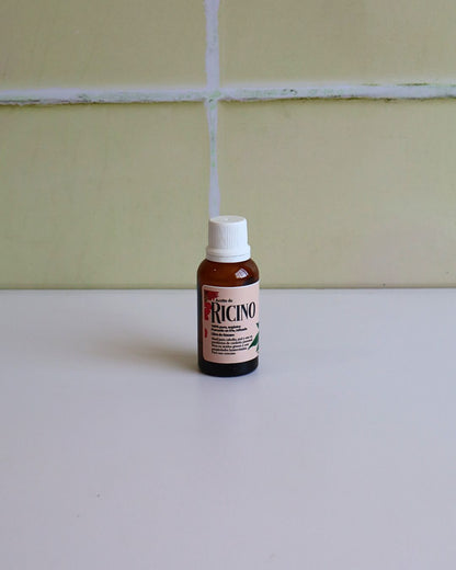 Aceite de ricino puro en frasco pequeño con flores naturales