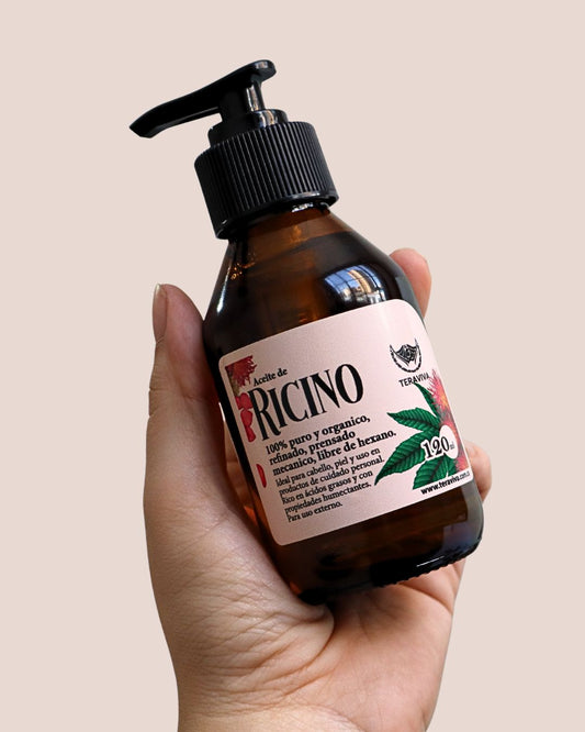 Mano sosteniendo frasco grande de aceite de ricino 120 ml