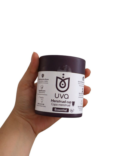 Empaque cerrado de la copa menstrual talla uva en la mano