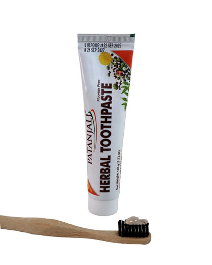 Cepillo de bambú y crema dental herbal Patanjali sobre superficie natural