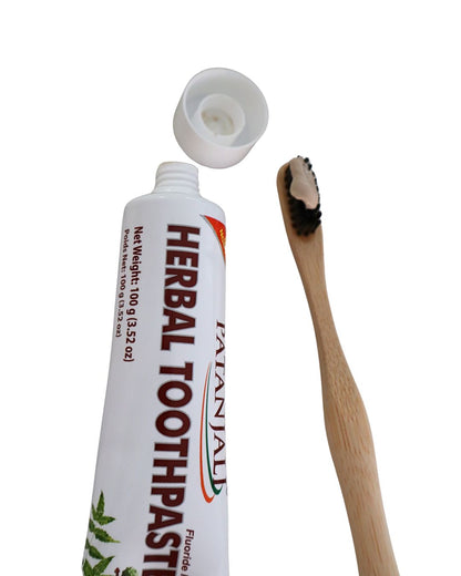Tubo de crema dental herbal Patanjali junto al cepillo de dientes