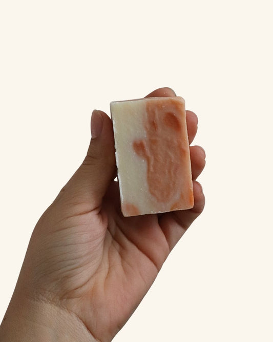 Mano sosteniendo jabón facial de manzanilla para piel sensible