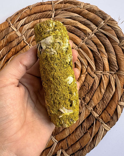 Mano sosteniendo atado de salvia con ruda encendido en ritual
